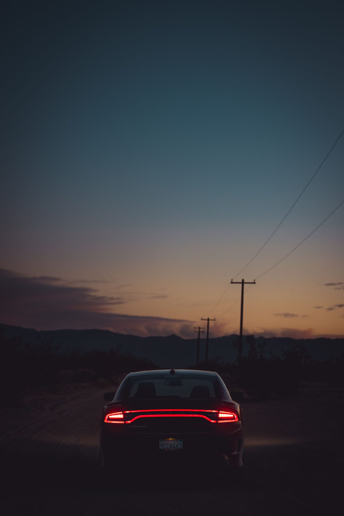 Carro visto de costas em uma estrada ao entardecer